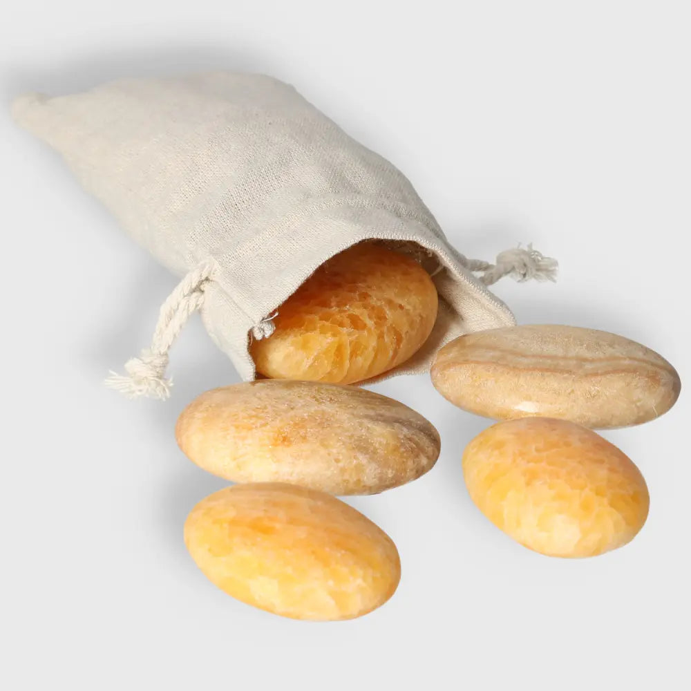 Orange Calcite Palm Stones, hand-polished, with a linen pouch for energy work, healing, and meditation.