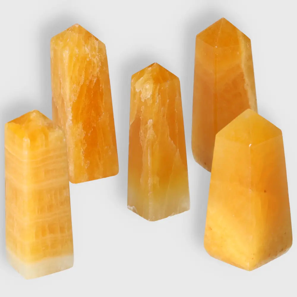 Five orange calcite towers with polished points for energy flow, ideal for emotional healing and creativity in meditation or home decor.