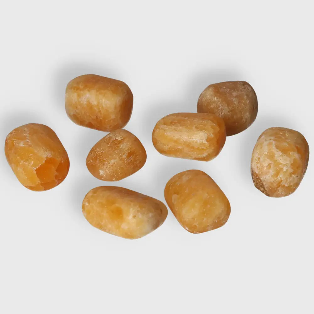 Tumbled orange calcite stones showcasing vibrant hues, symbolizing positivity and creativity, ideal for emotional healing and energy work.