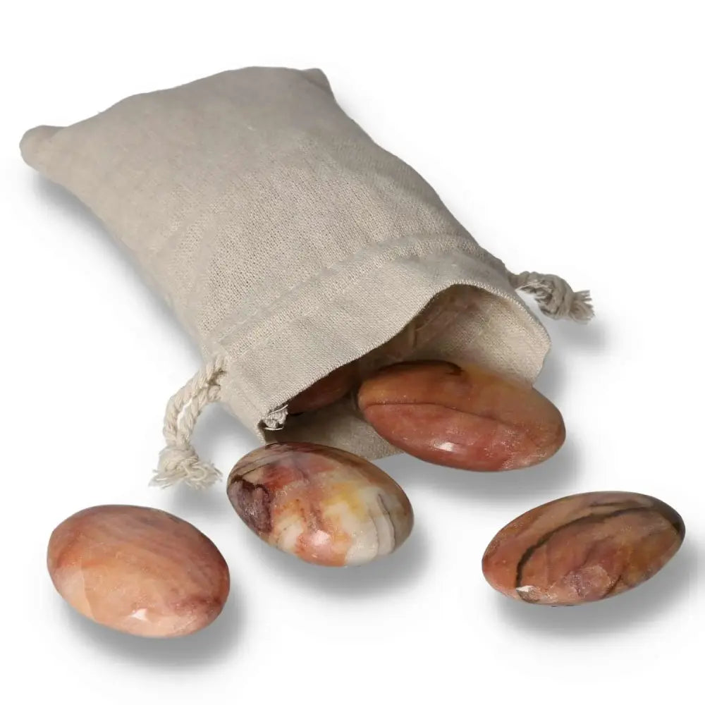 Peach Calcite Palm Stones in a linen pouch for emotional healing and meditation, showcasing soft peach hues.