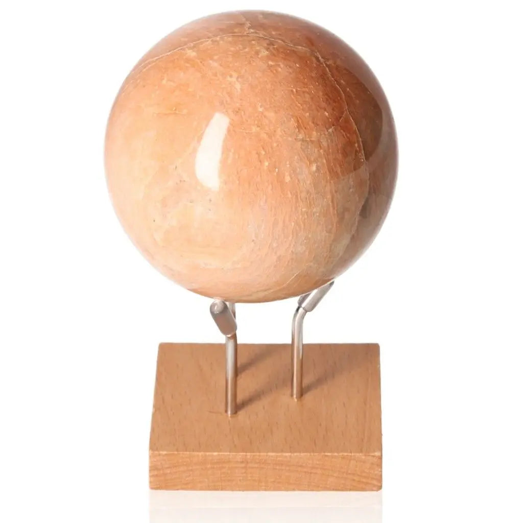 Peach Moonstone Sphere on stand, showcasing its gentle peach hue, renowned for promoting calmness and emotional healing