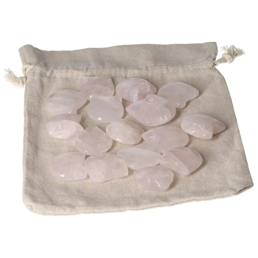 Collection of small pink quartz stones on a beige cloth pouch, displayed for decorative or healing purposes.