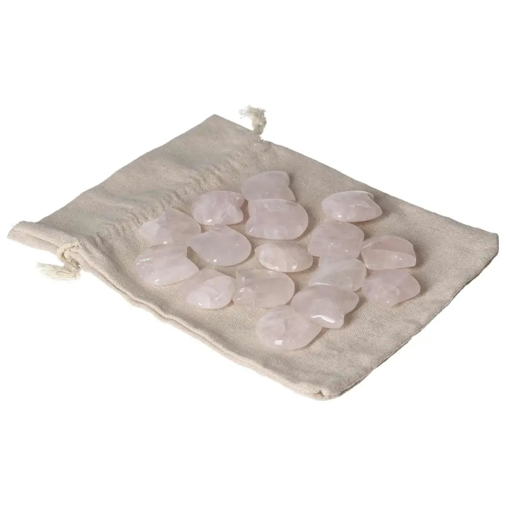Collection of small pink quartz stones on a beige cloth bag