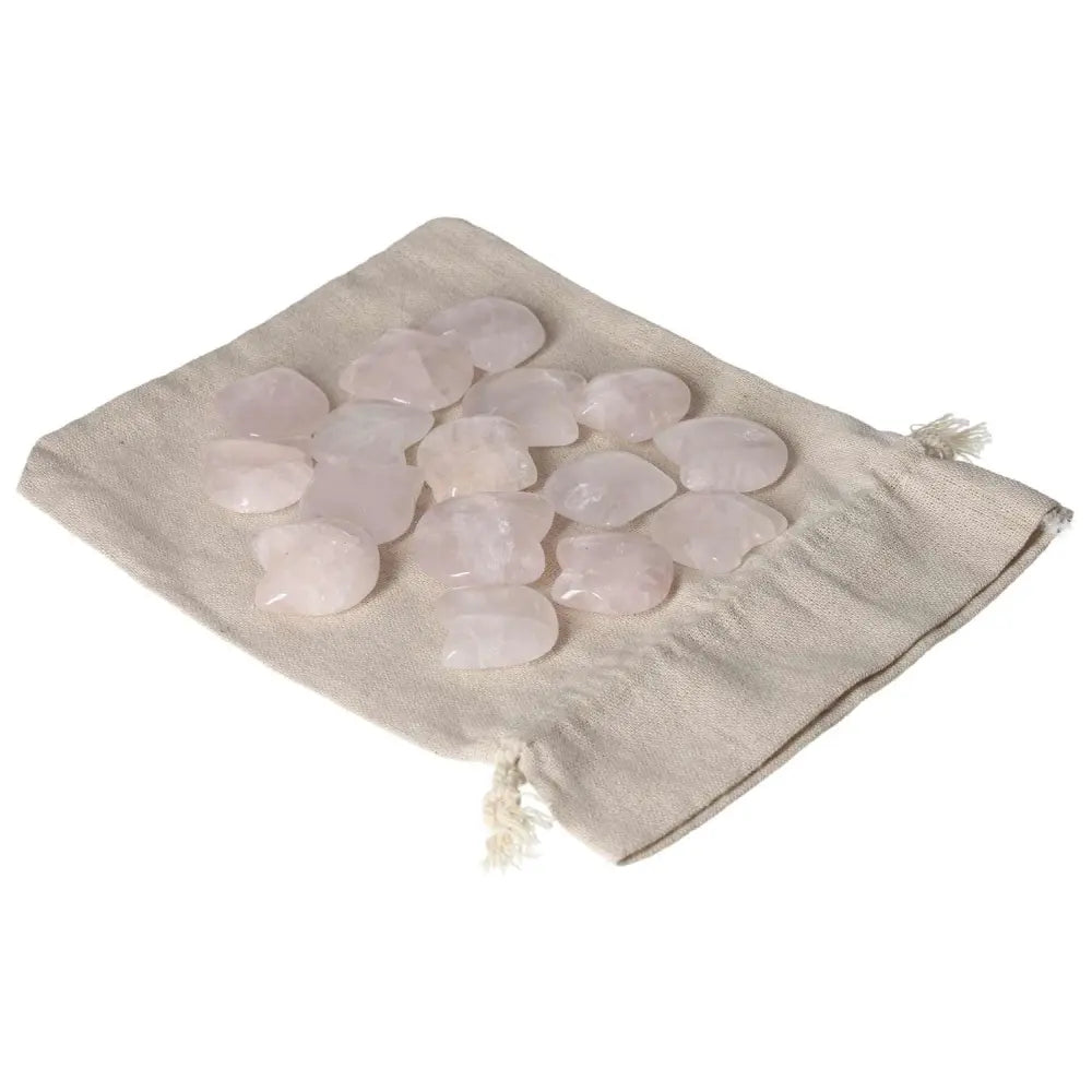 Collection of rose quartz cat figurines on a beige fabric pouch