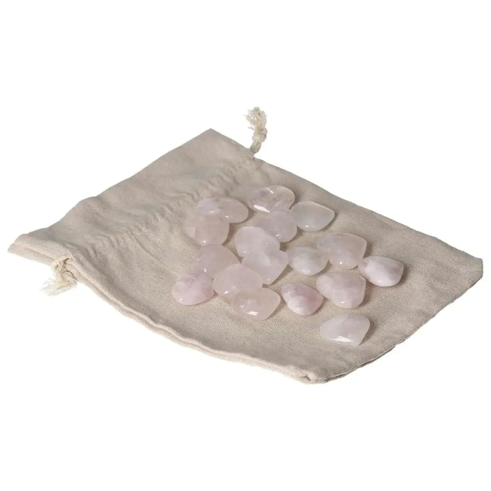 Small pink quartz heart stones on a fabric pouch