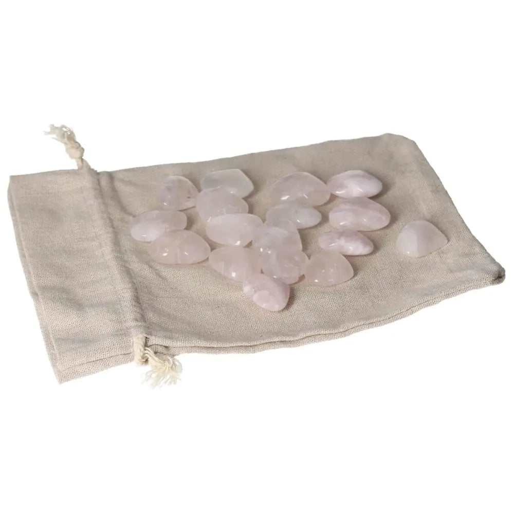 Pink quartz small hearts on a beige cloth bag, ideal for crystal healing and decoration.