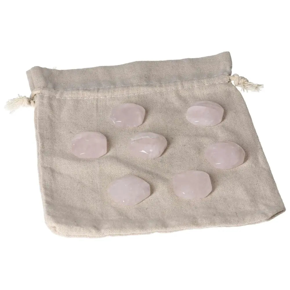 Set of small pink quartz palmstones on a fabric pouch, perfect for heart chakra healing and emotional balance.