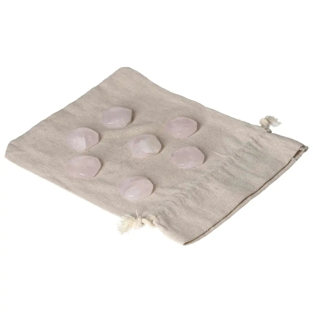 Set of small polished pink quartz palmstones on a linen pouch, ideal for love and emotional healing, supporting heart chakra balance.