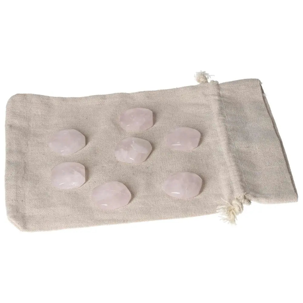 Pink Quartz Palmstones on a beige pouch, showcasing smooth polished crystals for emotional healing and heart chakra support.