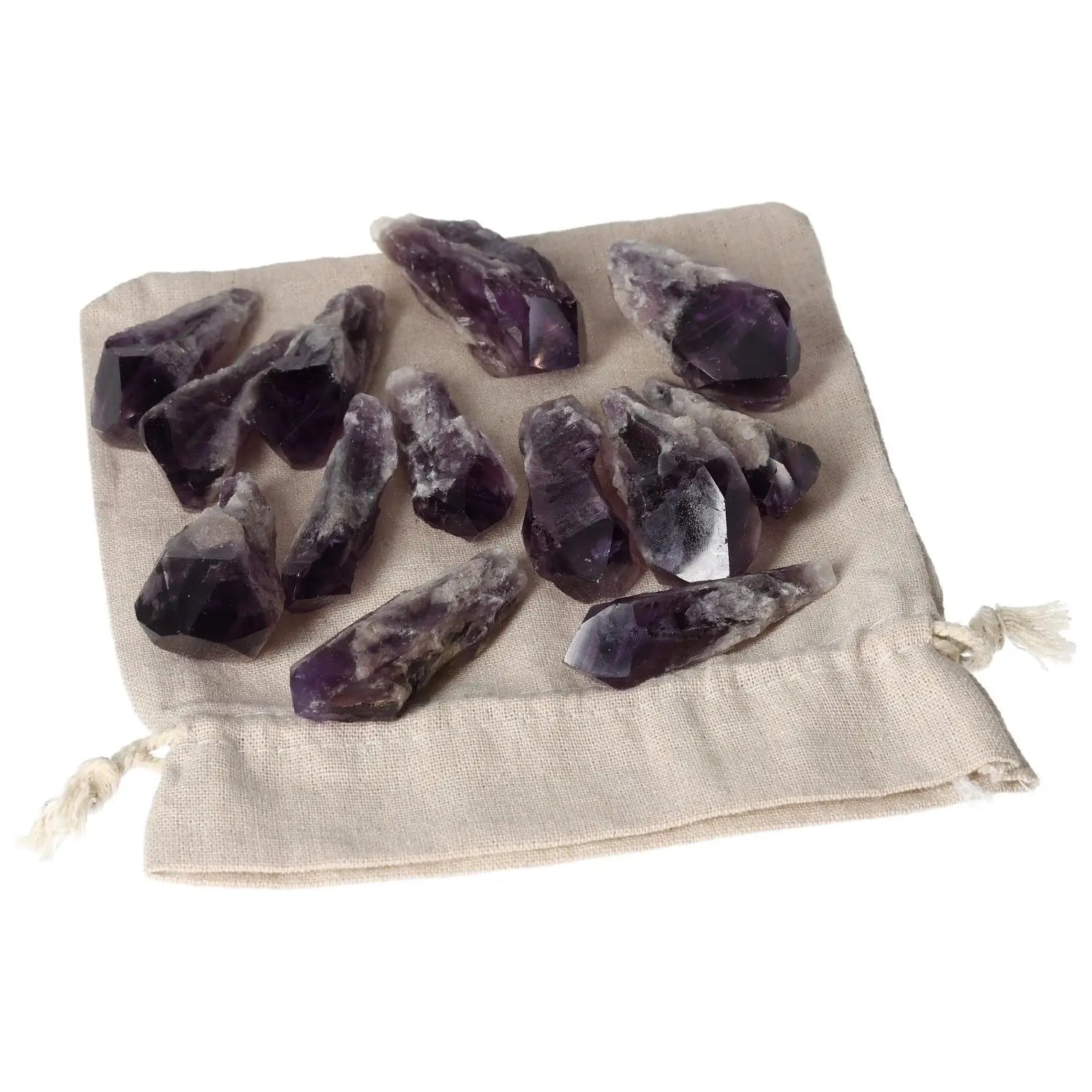 Set of Amethyst crystal tips on a beige cloth backdrop, ideal for reducing stress and enhancing concentration; a premium Sylvia Crystals product.