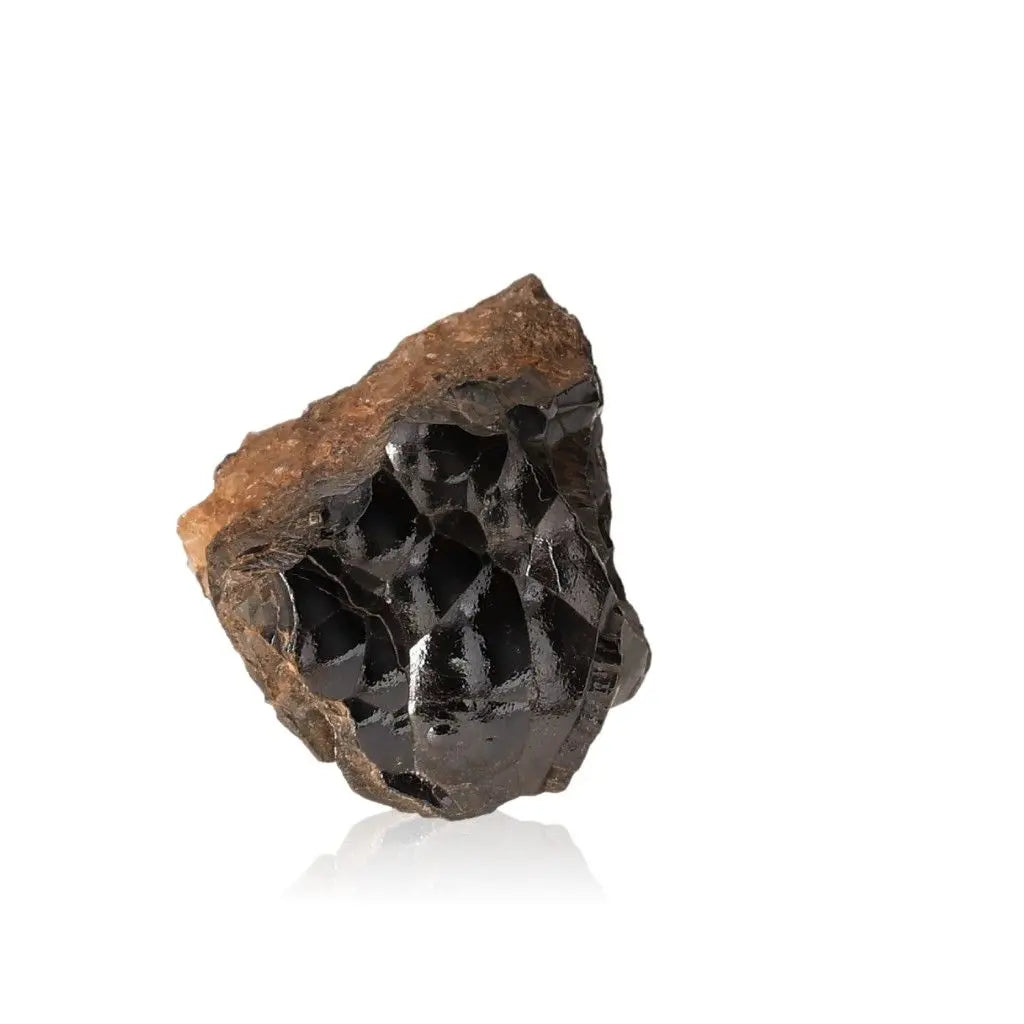 Polished botryoidal hematite crystal, shimmering metallic cluster for grounding and shield against negativity, reflecting light on white background.
