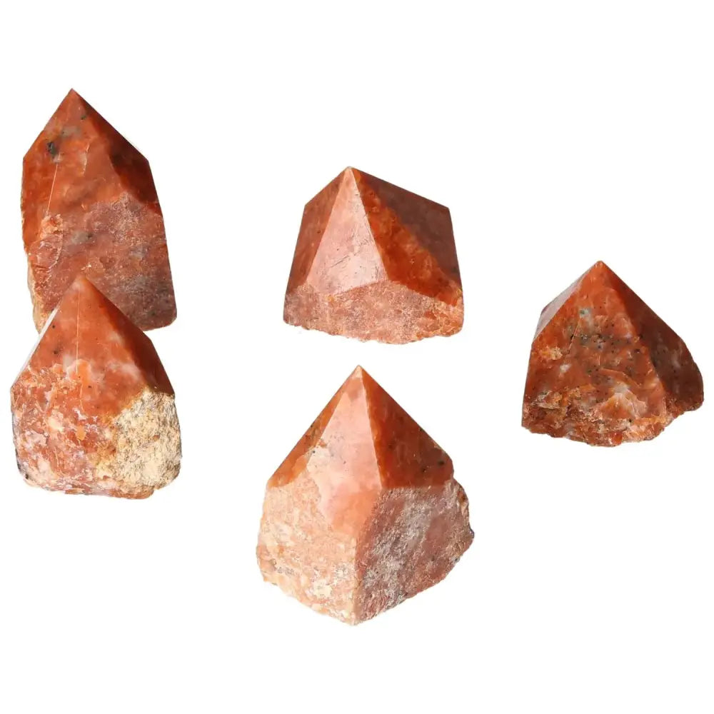 Group of polished orange calcite crystals symbolizing willpower and creativity, from Sylvia Crystals collection.