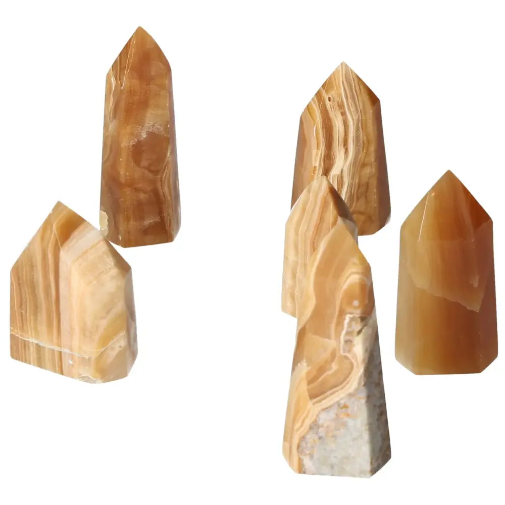 Elegant Polished Point Honey Calcite crystals from Sylvia Crystals, symbolizing prosperity and abundance with a warm honey hue.
