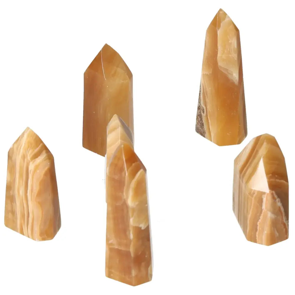 Five polished Honey Calcite crystal points from Sylvia Crystals symbolizing prosperity and positive transformation.