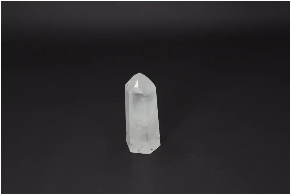 Polished Quartz Obelisk by Sylvia Crystals against black background, showcasing its beauty and energy as a premium decorative piece.