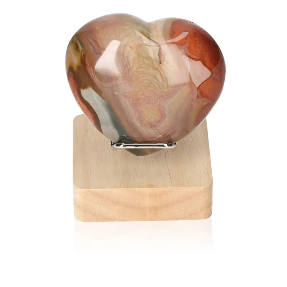 Polychrome Jasper Heart displaying vibrant earthy colors on a wooden stand, showcasing nature's artistry and the stone's unique patterns.