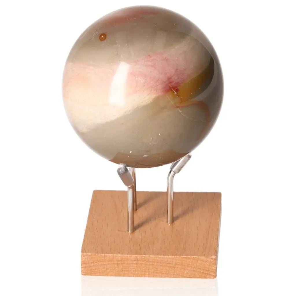Polychrome Jasper Sphere with vibrant colors on a wooden stand, showcasing a blend of reds, browns, and greens.