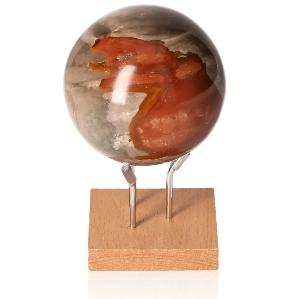 Polychrome Jasper Sphere with vibrant reds and earthy tones on wooden stand, showcasing nature's beauty and gemstone artistry.