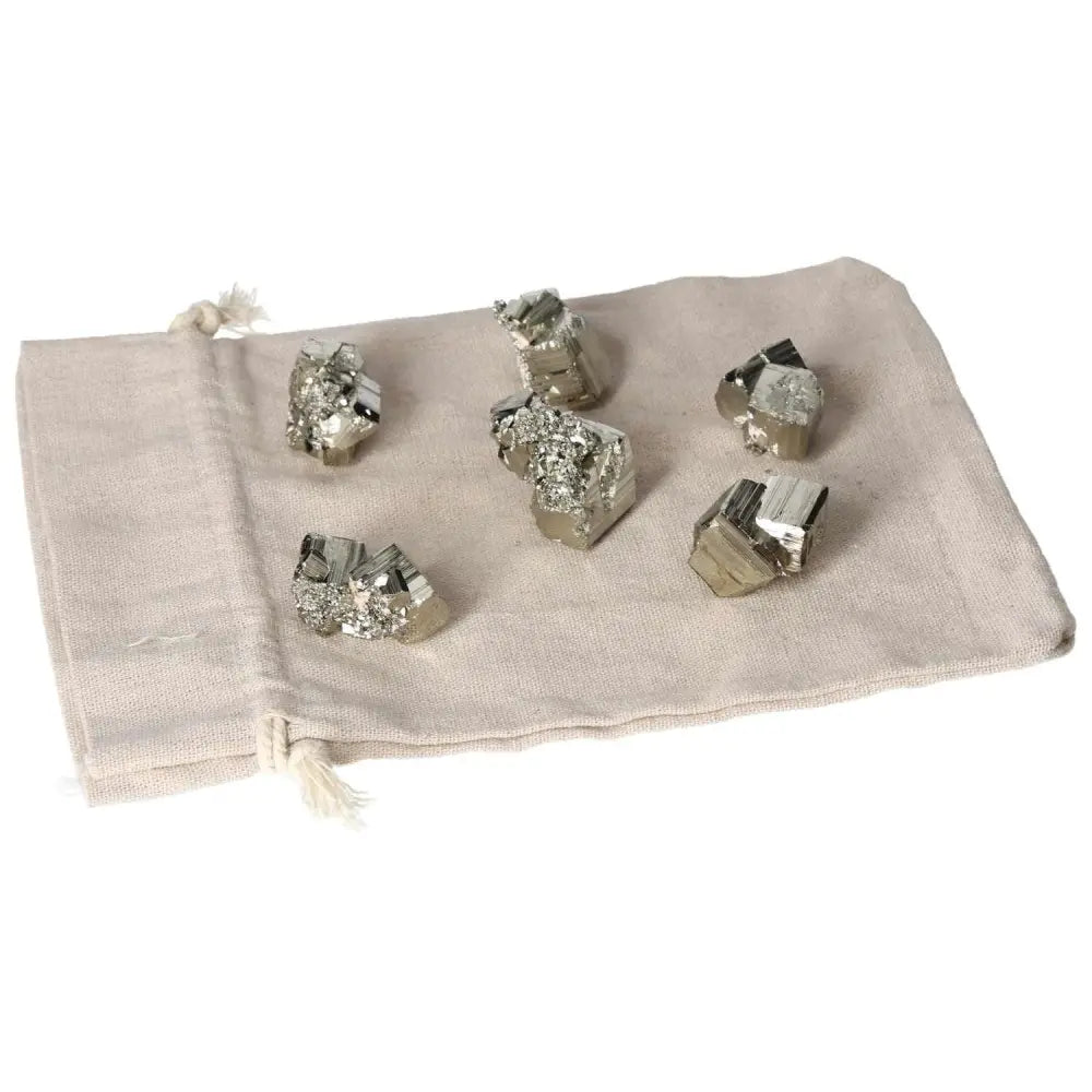 Pyrite cubes on a beige cloth, showcasing polished metallic luster, ideal for energy and decor enhancement.
