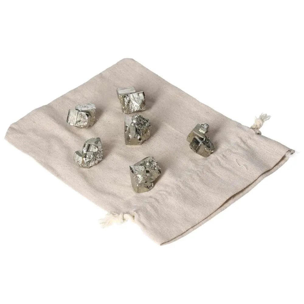 Alt Tag: Polished pyrite cubes on a cloth bag, showcasing golden luster and grounding energy, ideal for enhancing space and energy.