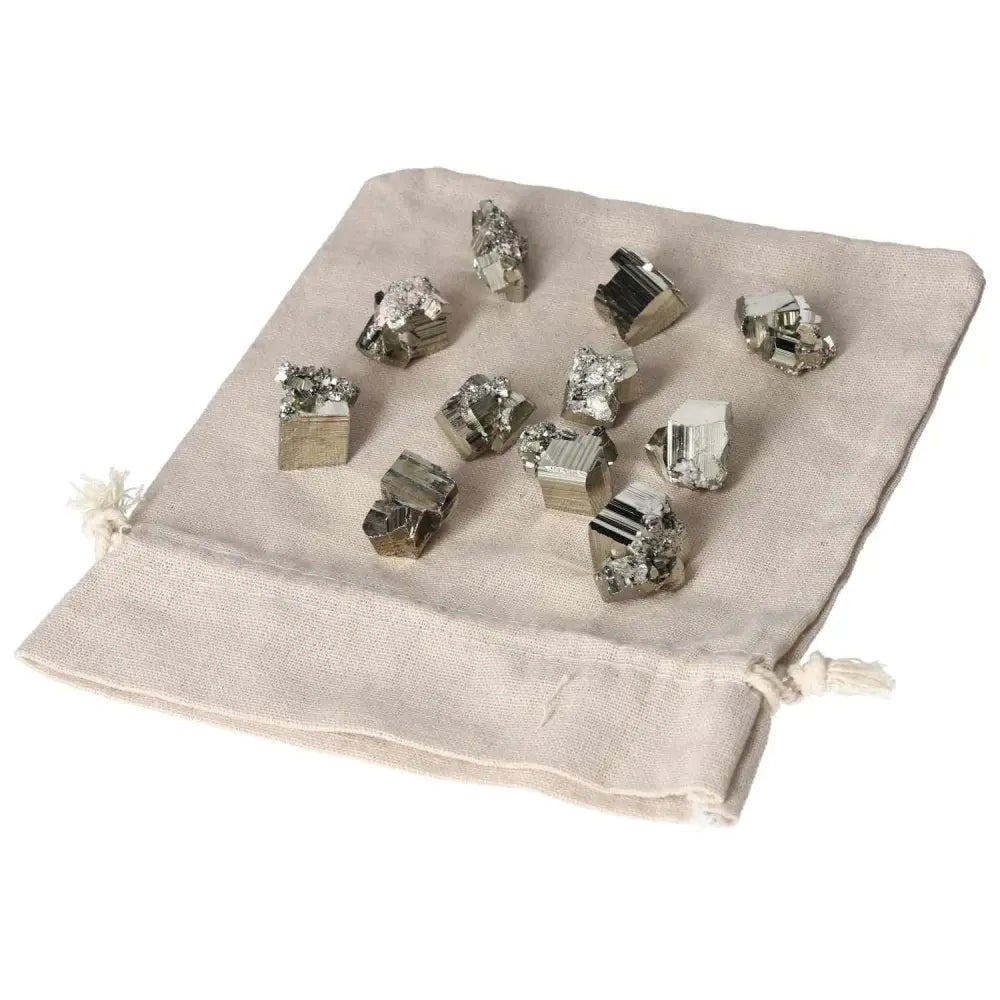Polished pyrite cubes on a beige fabric pouch, showcasing natural golden luster and quality craftsmanship.