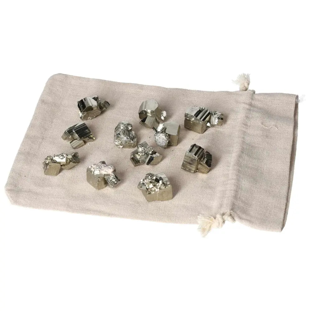 Collection of polished pyrite cubes on a beige cloth, showcasing their golden luster and grounding energy, ideal for home decor.