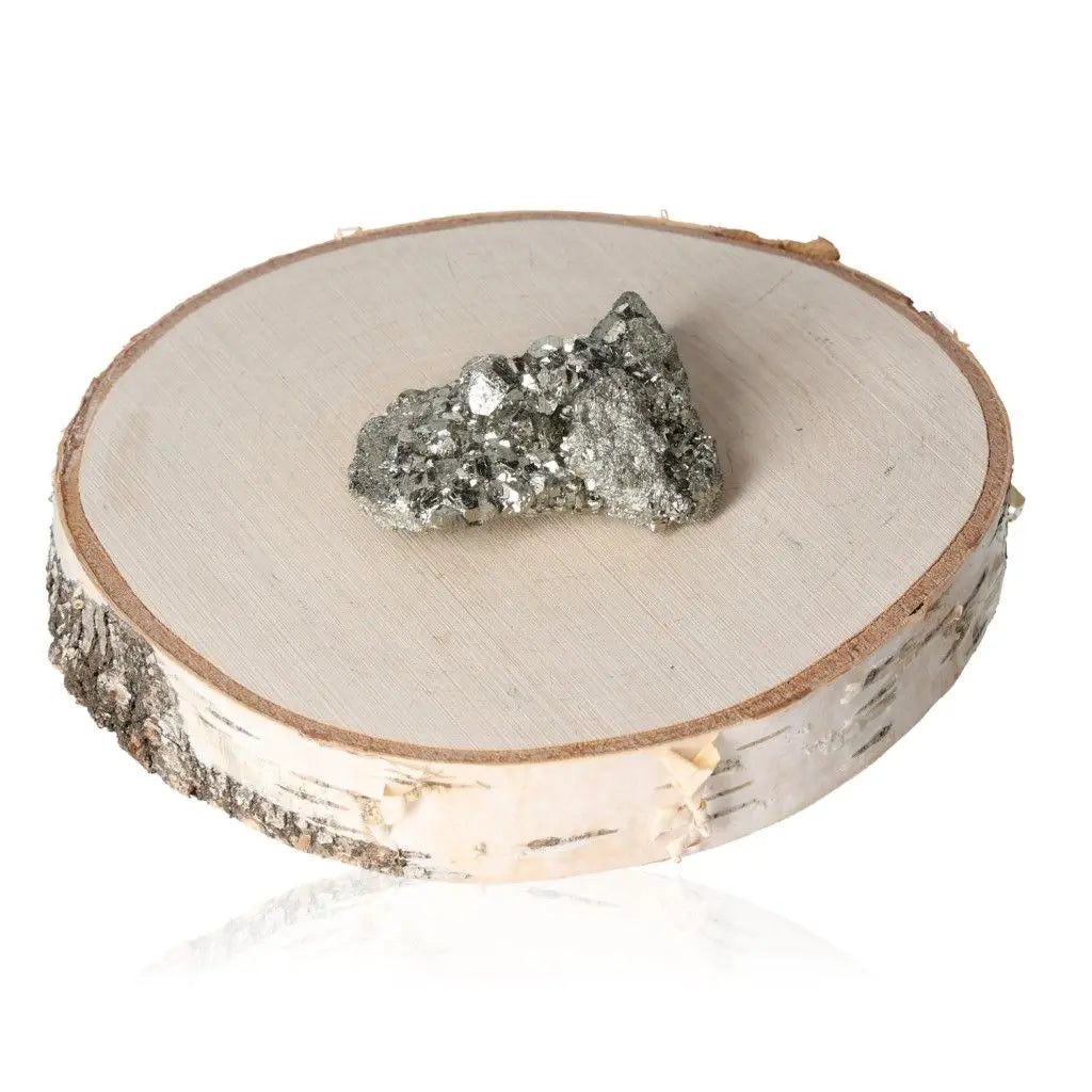 Pyrite druze gemstone with metallic luster on wooden slab, natural mineral known as Fool's Gold, symbolic of abundance.