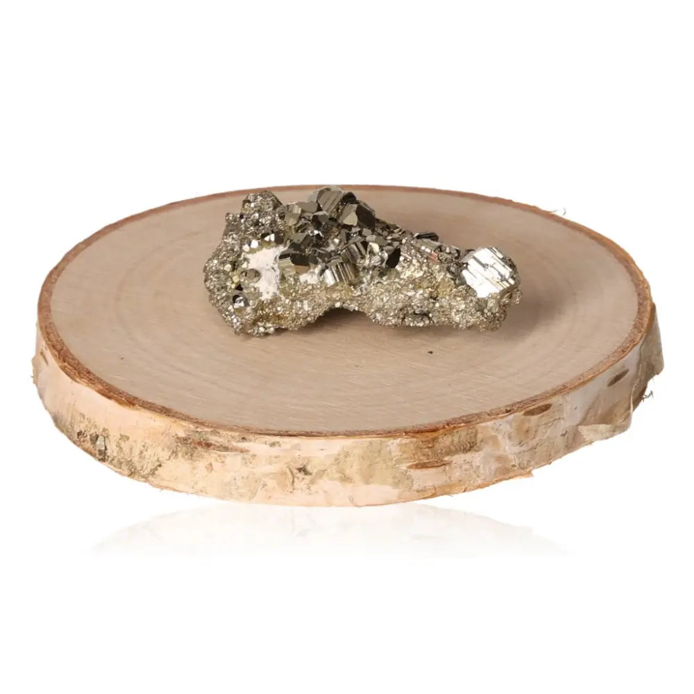 Pyrite druzy displayed on a wooden slice, showcasing its sparkling golden hue and metallic luster, symbolizing abundance and prosperity.