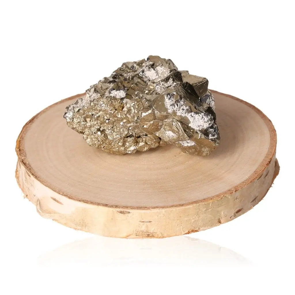 Pyrite druzy stone displaying golden hue and metallic luster, known for symbolic prosperity, placed on a wooden slice background.