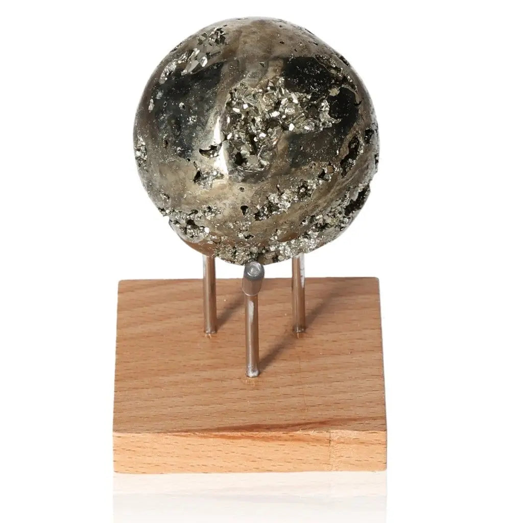 Pyrite sphere on a wooden stand, showcasing its golden hue and metallic luster, symbolizing abundance and prosperity.