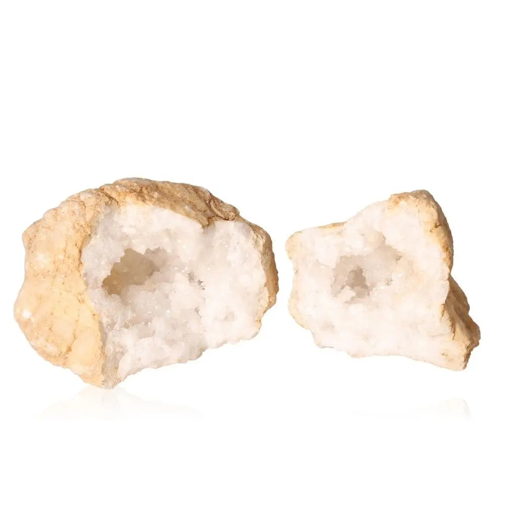 Quartz Geode split open revealing sparkling cloudy white crystals on a white background.