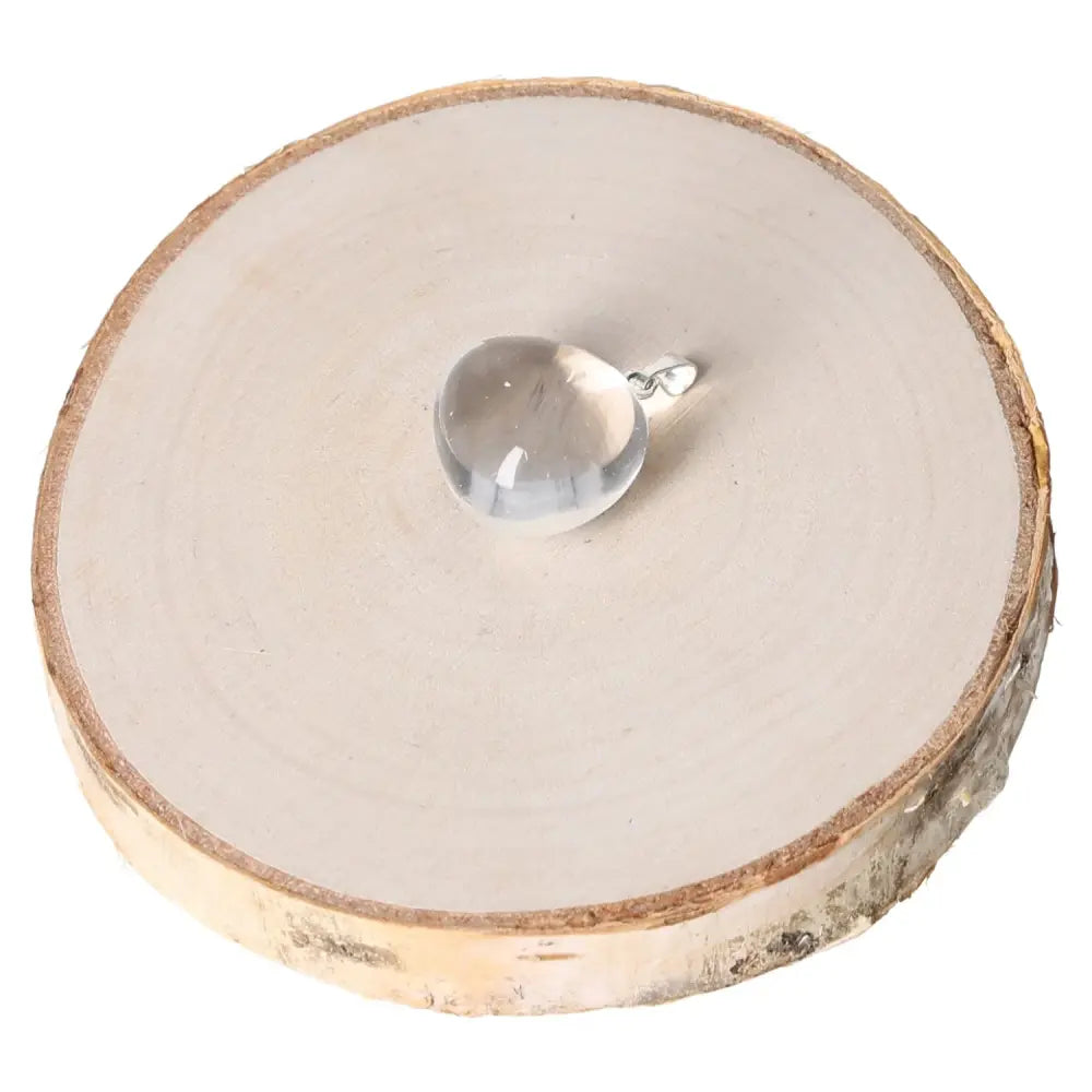 Rock Crystal AA Tumbled Pendant on a wood slab, showcasing premium quality and natural elegance.