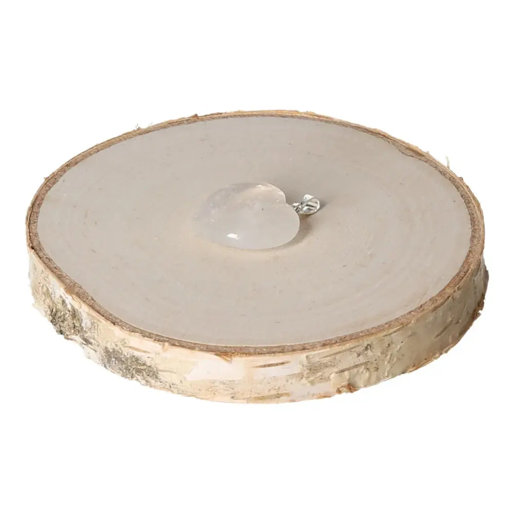 Rock Crystal Heart Pendant 20mm on wooden slice, symbolizing elegance and spirituality from Sylvia Crystals.
