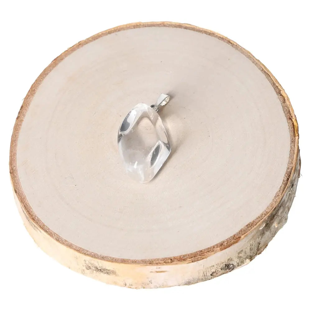 Rock Crystal Tumbled Pendant on wood slice, showcasing its natural clarity and elegance. Ideal for crystal enthusiasts and jewelry lovers.