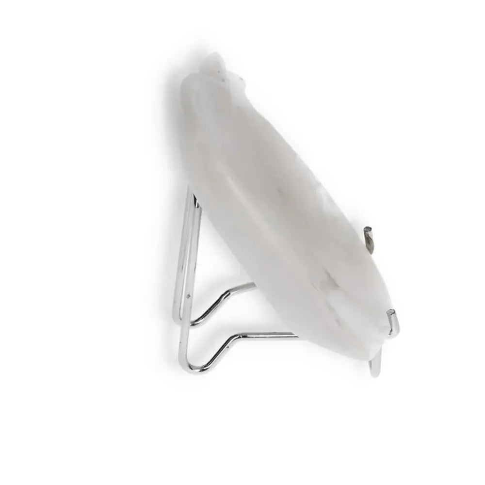 Side view of a white onyx platter resting on a metal stand, showcasing its sleek design and smooth, polished finish.