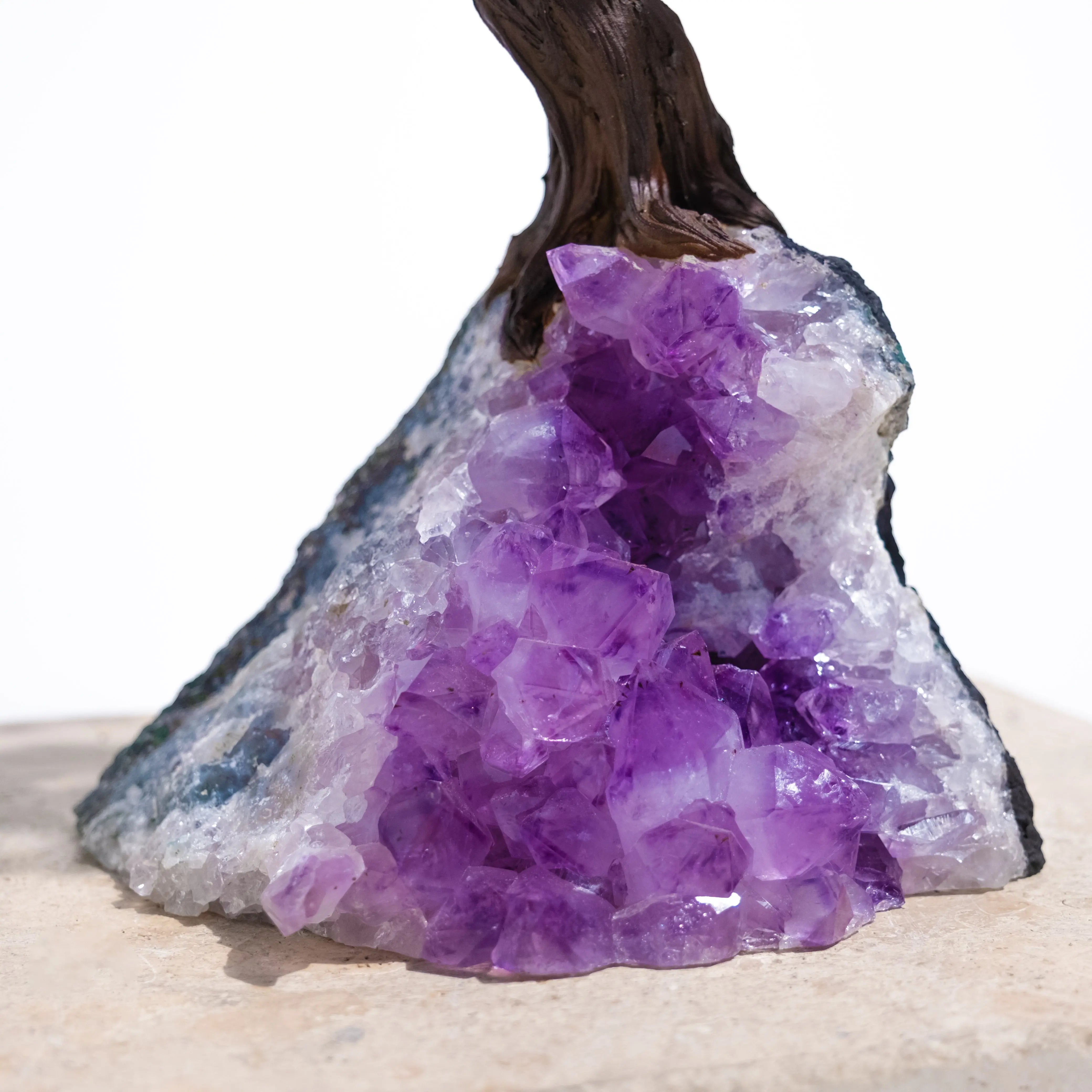 Close-up of amethyst crystals at the base of a Rough Amethyst Tree, promoting calm and spiritual harmony.