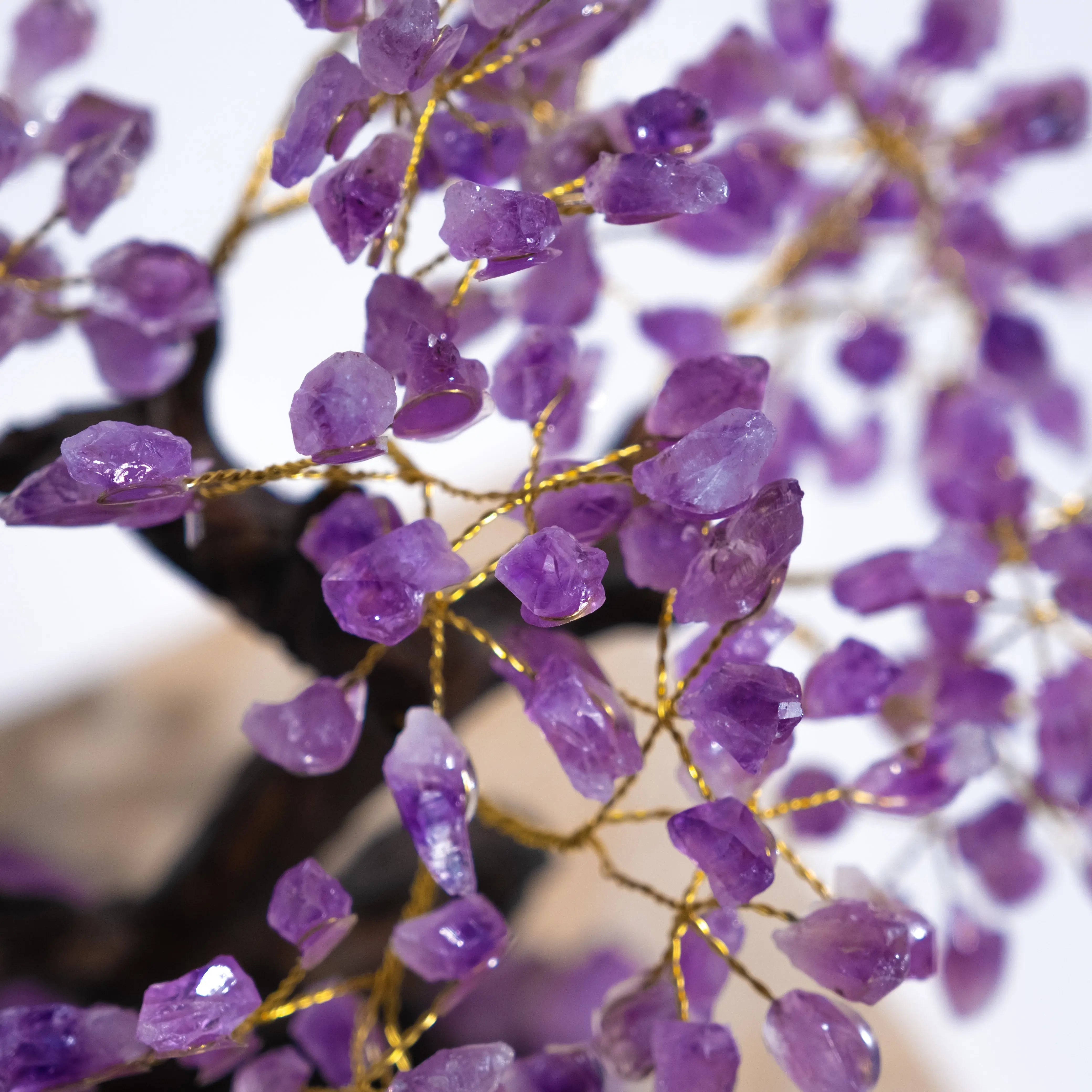 Close-up of handcrafted amethyst crystal bonsai tree with purple gemstone leaves, symbolizing calming energy and spiritual harmony.