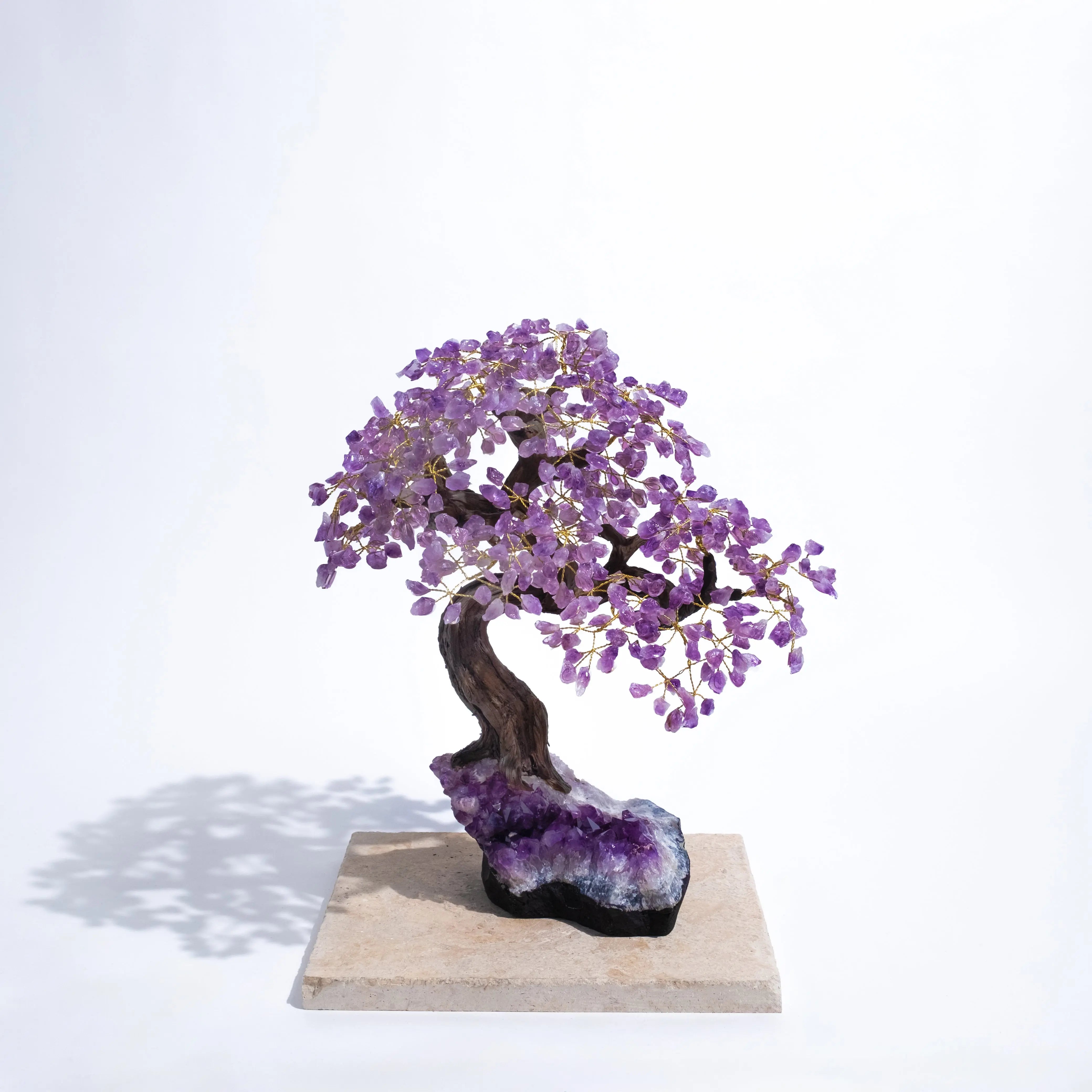 Elegant amethyst crystal bonsai tree with purple gemstone leaves, promoting tranquility and protection, 55 cm tall on a stone base.