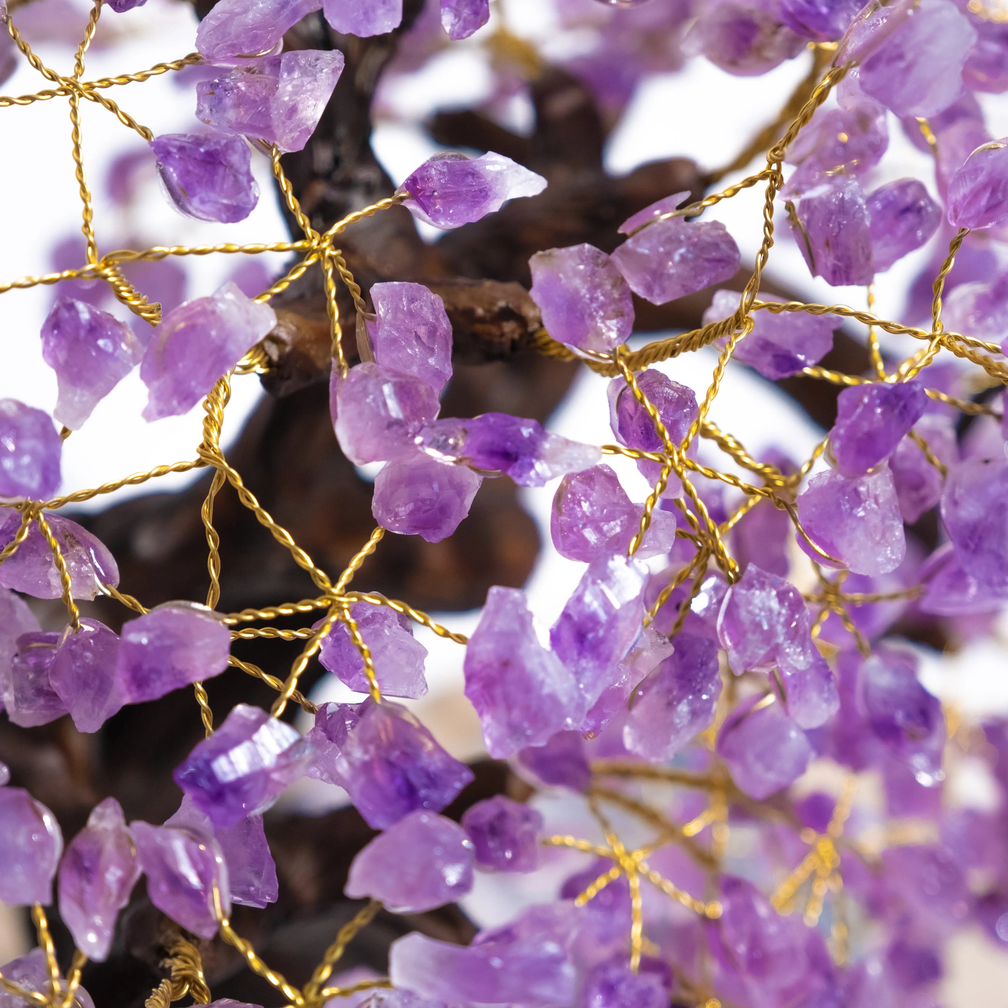 Close-up of an amethyst crystal bonsai tree with purple gemstone leaves, symbolizing tranquility and protection.