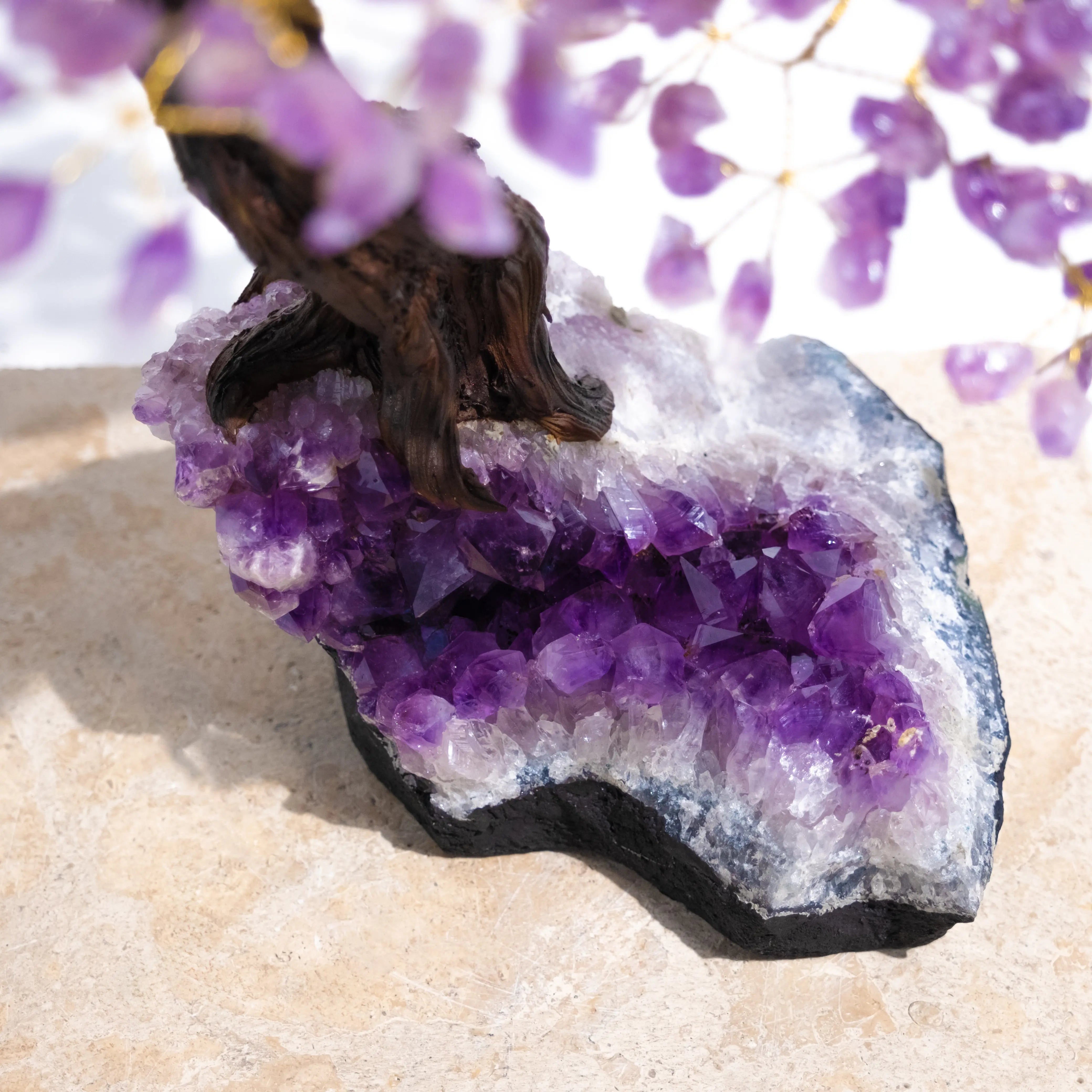 Amethyst crystal bonsai tree with vibrant gemstone leaves for calming energy and spiritual harmony on a stone base