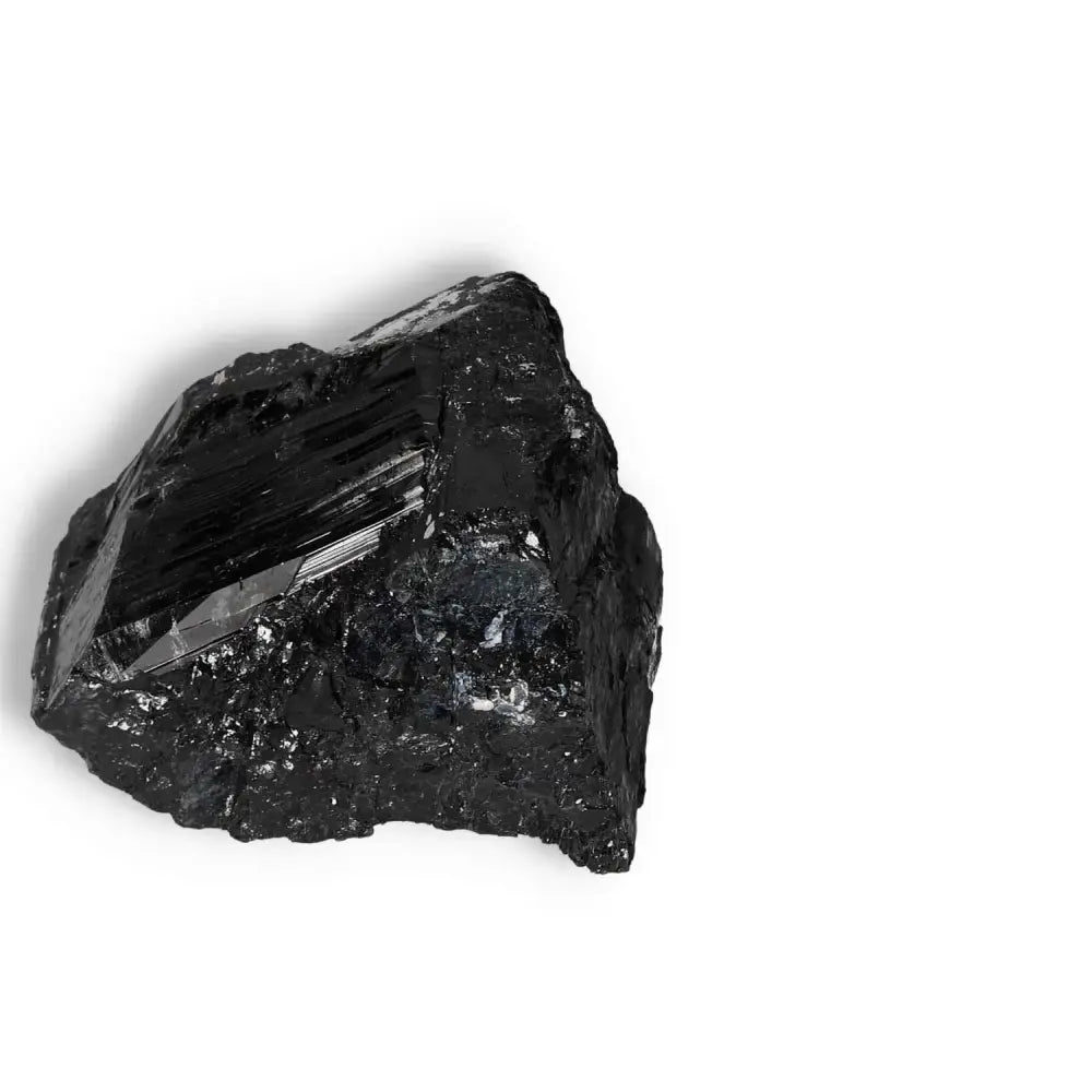 Rough Black Tourmaline Druze L by Sylvia Crystals, known for its cleansing and grounding properties, placed against a white background.