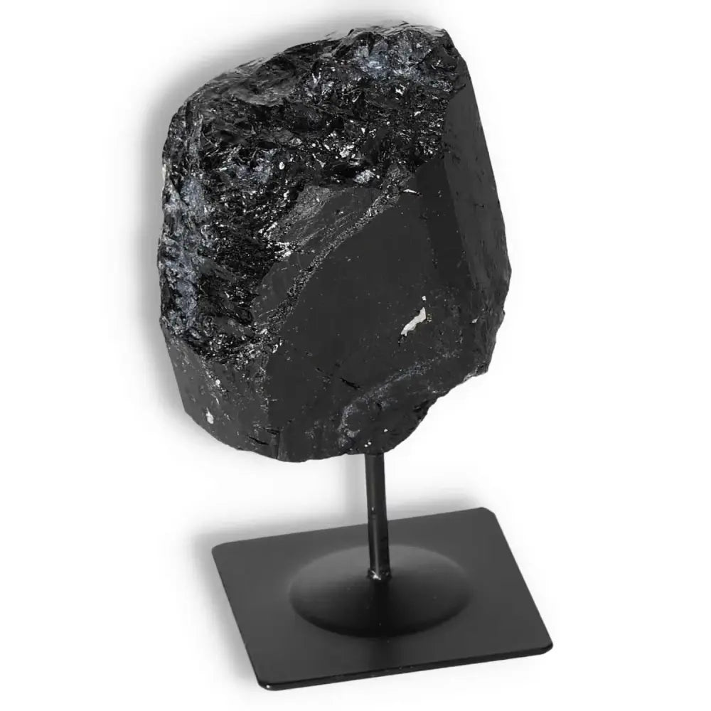 Rough Black Tourmaline on metal stand from Sylvia Crystals, ideal for spiritual cleansing and neutralizing negative energy.