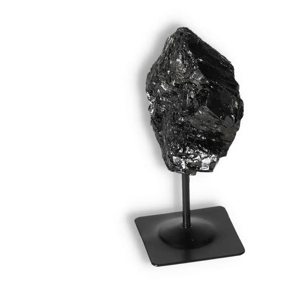 Rough Black Tourmaline on metal stand from Sylvia Crystals, known for its cleansing properties and spiritual grounding luxury.