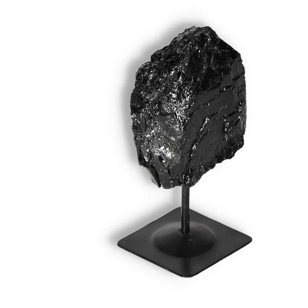 Rough Black Tourmaline on metal stand, from Sylvia Crystals, known for cleansing negative energies and creating a balanced atmosphere.
