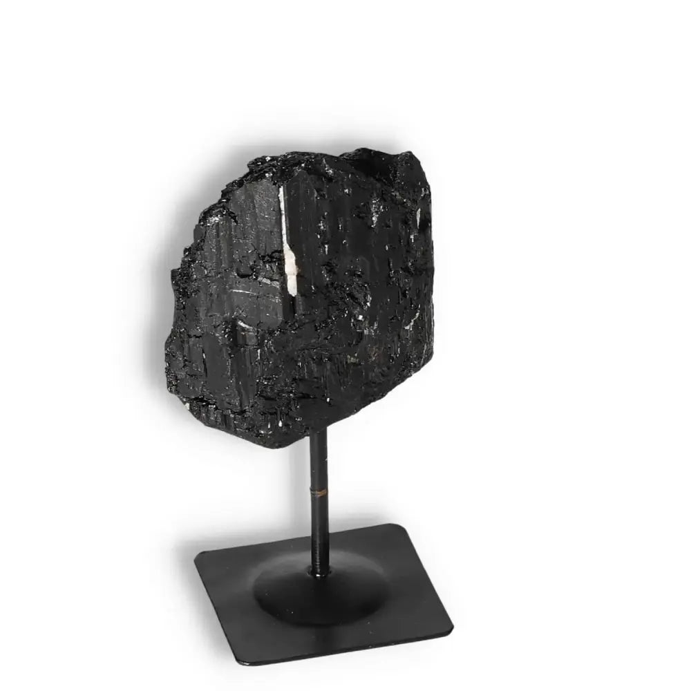 Rough Black Tourmaline on metal stand, luxury crystal from Sylvia Crystals, known for cleansing and transforming negative energy.