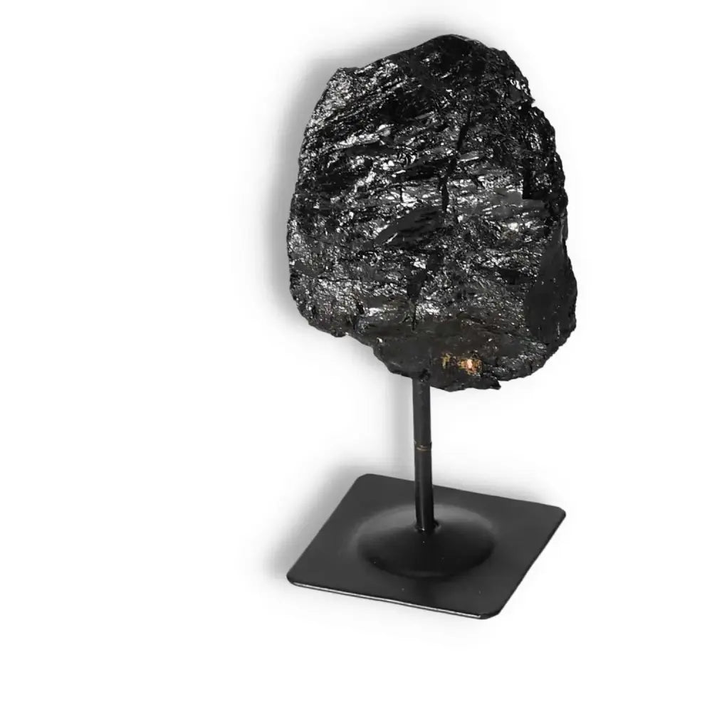Rough Black Tourmaline on metal stand, luxurious Sylvia Crystals product enhancing elegance and spirituality in conscious living.