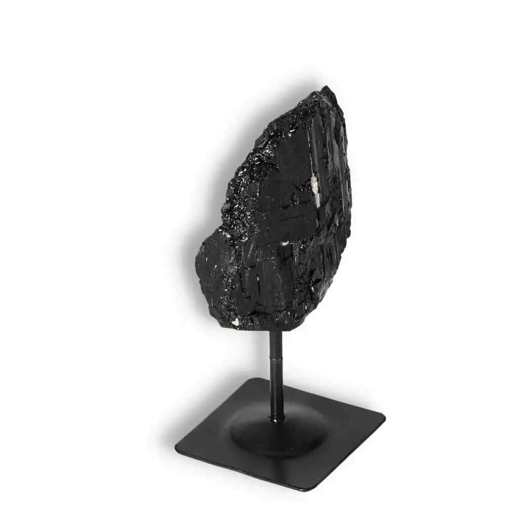 Rough Black Tourmaline on a metal stand, exuding luxury and spirituality from Sylvia Crystals, ideal for conscious living spaces.