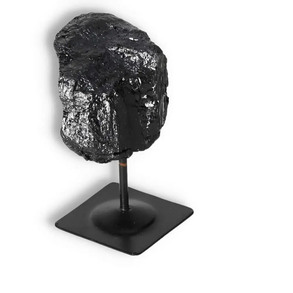 Rough Black Tourmaline on a metal stand, premium quality crystal from Sylvia Crystals, known for energy transformation and protection.