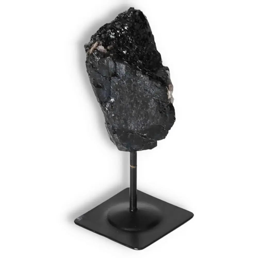 Rough Black Tourmaline on metal stand by Sylvia Crystals, showcasing luxury and transformative properties for balance and positivity.