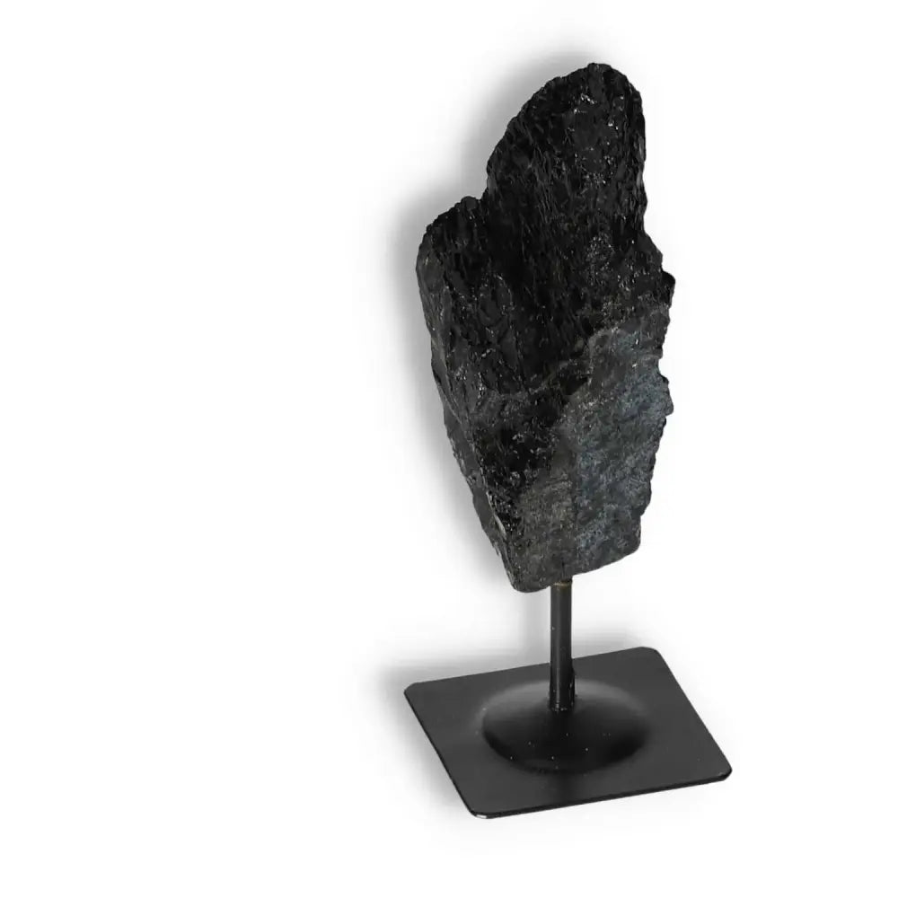 Rough Black Tourmaline on metal stand, a spiritual cleansing tool by Sylvia Crystals, ideal for transforming negative energies.